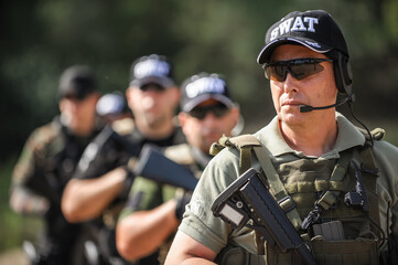 Group of full armed swat soldiers standing in column line - obrazy, fototapety, plakaty