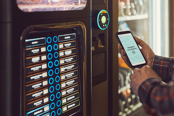 Consumer paying for product at vending machine using contactless method of payment with mobile...