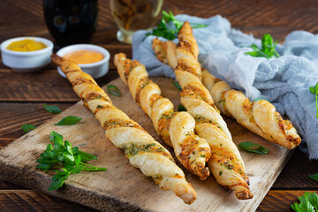 Puff sticks with cheese and herbs. Homemade breadsticks with sauce