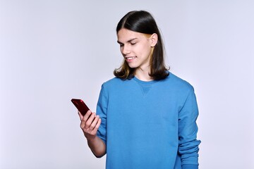 Fototapeta premium Guy with smartphone in his hand, on light studio background