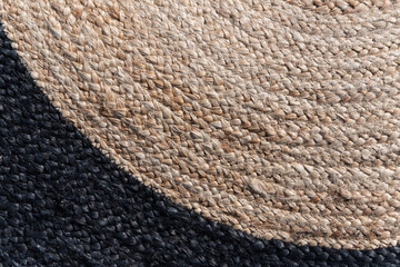 Detail of round strips of a wicker mat in natural and black. Background image