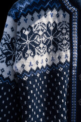Blue handmade woolen Scandinavian ladies cardigan, Norwegian style sweater with patterns hanging in an open air market stall