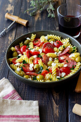 Salad with fusilli pasta, sausage, olives and cottage cheese. Italian food.