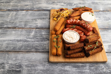 set of snacks: sausages, nuggets, cheese sticks, toast, cabbage salad. Side view, copy space.
