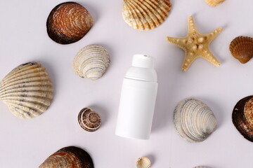 White plastic bottle on seashell background, mockup