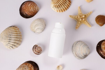 White plastic bottle on seashell background, mockup
