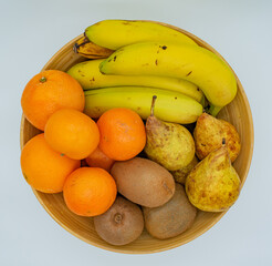 fruit bowl seen from above with orange, kiwi, banana and pear