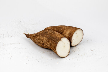 Tapioca / Kappa - roots of the cassava plant, cut and whole isolated in extendable white background shot using studio lights, Isolated, Nobody, Macro, Nutritious, Healthy Food, Roots, tropical food.  - obrazy, fototapety, plakaty