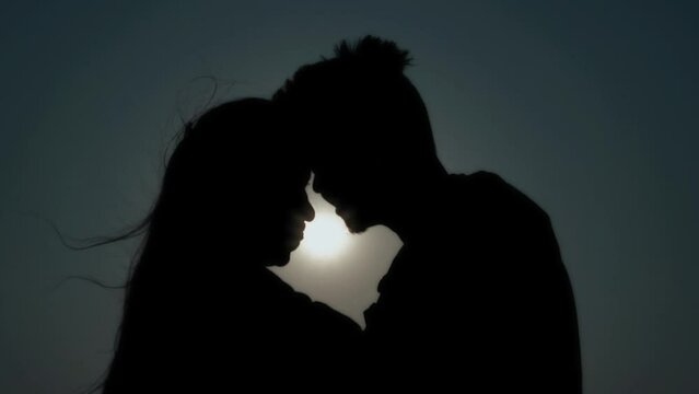 silhouette of a romantic couple, men and women touching head, couple love