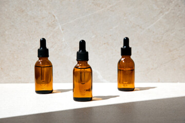Clear bottle with natural SPA cosmetics on a beige stone background. Front view