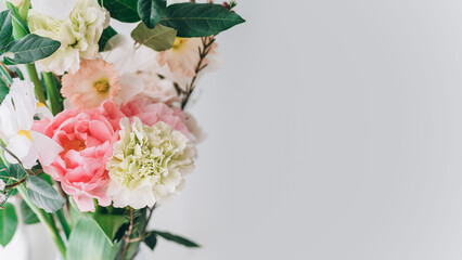 beautiful bouquet of carnations, daffodils, spray roses and white irises on a gray background, copy space
