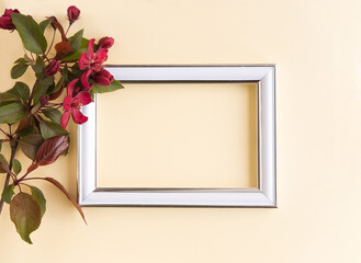 Obraz premium Beautiful flower arrangement. A branch of red flowers, an empty photo frame for text on a light pastel background. Wedding. birthday. Valentine's Day, Mother's Day. Top view, copy space