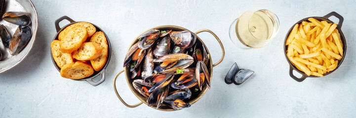 Mussels panorama. Seafood meal with shellfish, French fries and toasted bread, with white wine,...