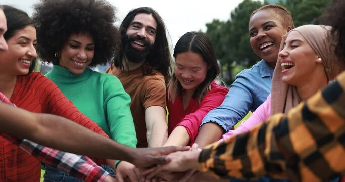 Young multiethnic people having fun stacking hands outdoor 