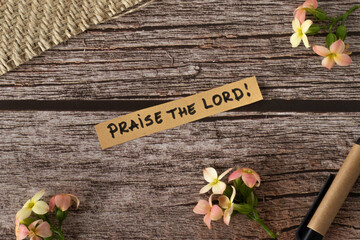 Praise the LORD, handwritten message quote from Christian Holy Bible on a wooden retro background...