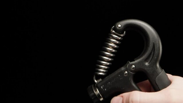 A man squeezes a hand trainer, expander.