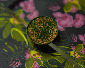 Dark green single glitter eye shadow on floral jungle background - obrazy, fototapety, plakaty
