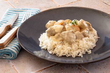 veal cooked with mushrooms and carrots mixed with rice on a plate