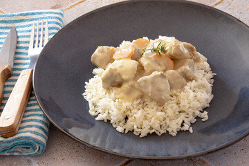 veal cooked with mushrooms and carrots mixed with rice on a plate