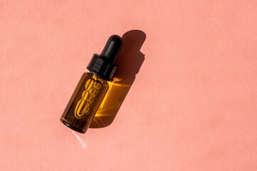 Transparent amber green glass dropper bottles with liquid inside on beige background in the sunlight. Pipette with fluid hyaluronic acid, serum, retinol. Cosmetics, healthcare, beauty 