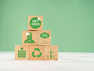 Net-zero emissions in 2050. World Earth day concept. Wooden cubes with eco-friendly icons over a...