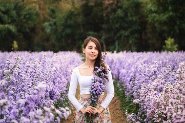 Beautiful young asian woman holding margaret flower in the garden