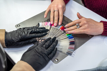 Master assisting client in choosing the perfect color with the varnish sample palette