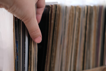close-up of female hands, choosing vinyl records, antiques, old furniture, tables, used things,...