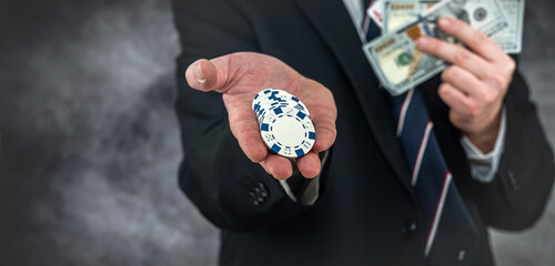 rich business man holding dollar and play card for poker game