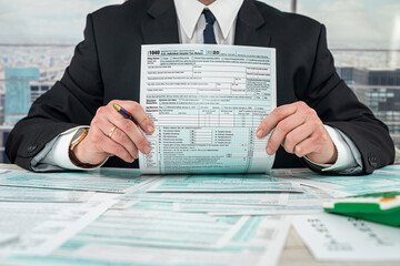 businessman working with documents 1040 tax form in office
