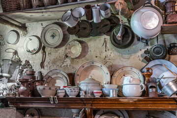 Museum exhibition of household utensils, pots, pans, amphorae and irons, antique or vintage hanging on the wall. Peschici, Foggia province, Puglia