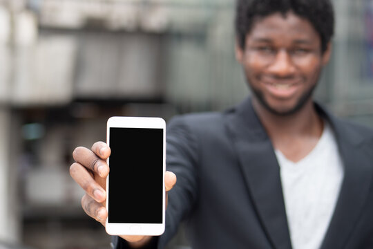 African businessman showing blank smartphone screen