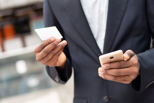 African businessman using smartphone and credit card for online electronic transaction