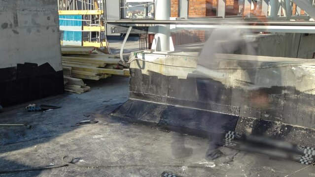 Roofer installing roofing felt with heating and melting of bitumen roll by torch on flame during roof repair timelapse. Construction process of roof covering and protection