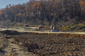 Preparatory construction work for the construction of a new asphalt road. - obrazy, fototapety, plakaty