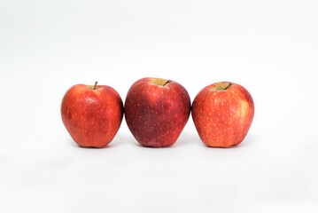 Three juicy ripe red apples isolated on white background. Healthy food.