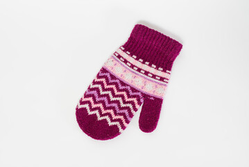 Knitted mitten made of pink wool isolated on a white background.