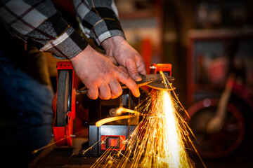 The process of sharpening scissors on metal with the release of a large number of bright sparks