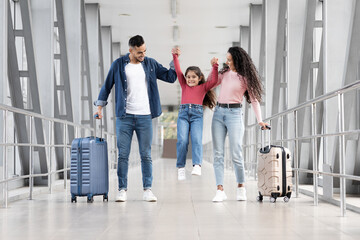Fototapeta premium Happy Arab Family Of three Having Fun Together While Walking In Airport