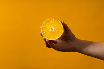 woman's hand holding half an orange
