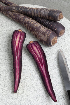 Purple carrot and slices on a cutting board close up