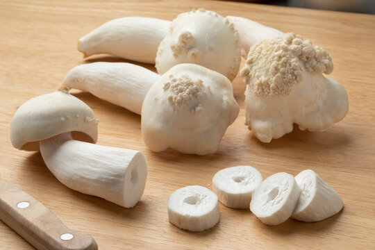 Fresh deformed cultivated beech mushrooms and slices  close up on a cutting board