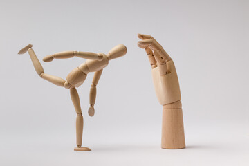 wooden dummy of a man swung his leg to hit a wooden hand on a white background
