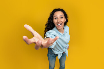 Excited young woman outstretching hand, trying to grab something - obrazy, fototapety, plakaty