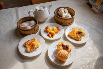 Dim sum platter combo set of traditional Cantonese yum-cha Asian gourmet cuisine meal food dish on the round table includes dishes of dumplings, pork buns, tea and steam baskets