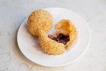 Chinese red bean paste sesame balls of traditional Cantonese yum-cha Asian gourmet cuisine meal food dish on the white serving plate and white table