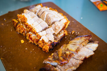 Traditional Cantonese yum-cha roast pork BBQ Asian gourmet cuisine with crispy golden pork skin on the chopping board