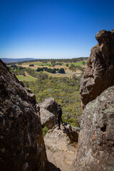 Cool man is overlooking the area from a landscape rock park Hanging Rock national park with rough stone structure and blue sky