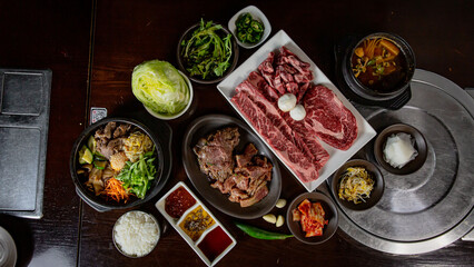 Top view Korean Grilled BBQ combo with wagyu and marinated beef set on the traditional grill table,...