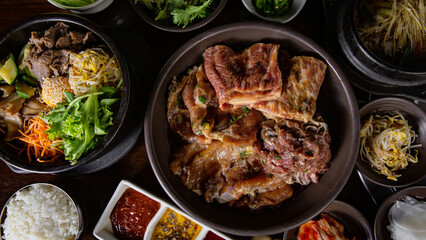 Top view Korean Grilled BBQ combo with marinated beef pork meat set on the traditional grill table,...